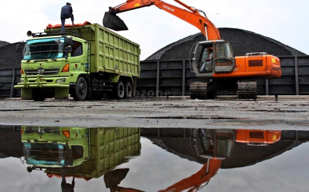 Ilustrasi tumpukan batu bara di dermaga ekspor dengan latar belakang grafik harga HBA yang menunjukkan tren kenaikan di bulan April 2026.