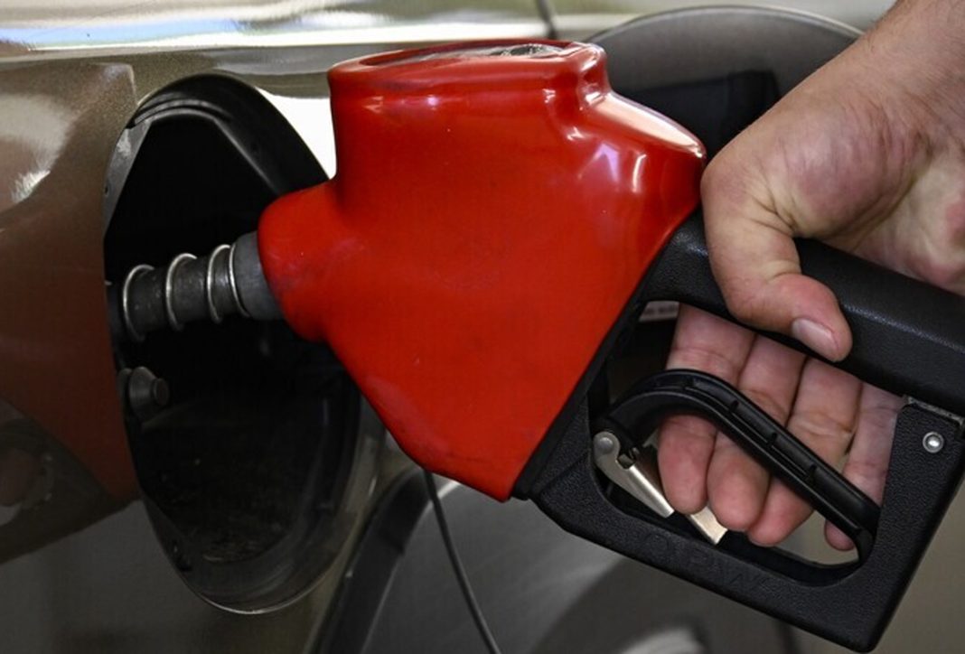 Kapal tanker minyak tertahan di pintu masuk Selat Hormuz dengan latar belakang fasilitas energi di Timur Tengah.